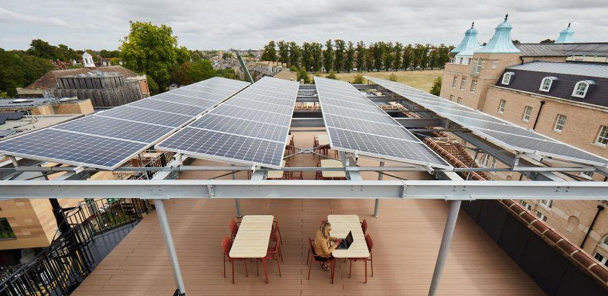 Roof top solar panels which people relaxing a chairs and tables beneath