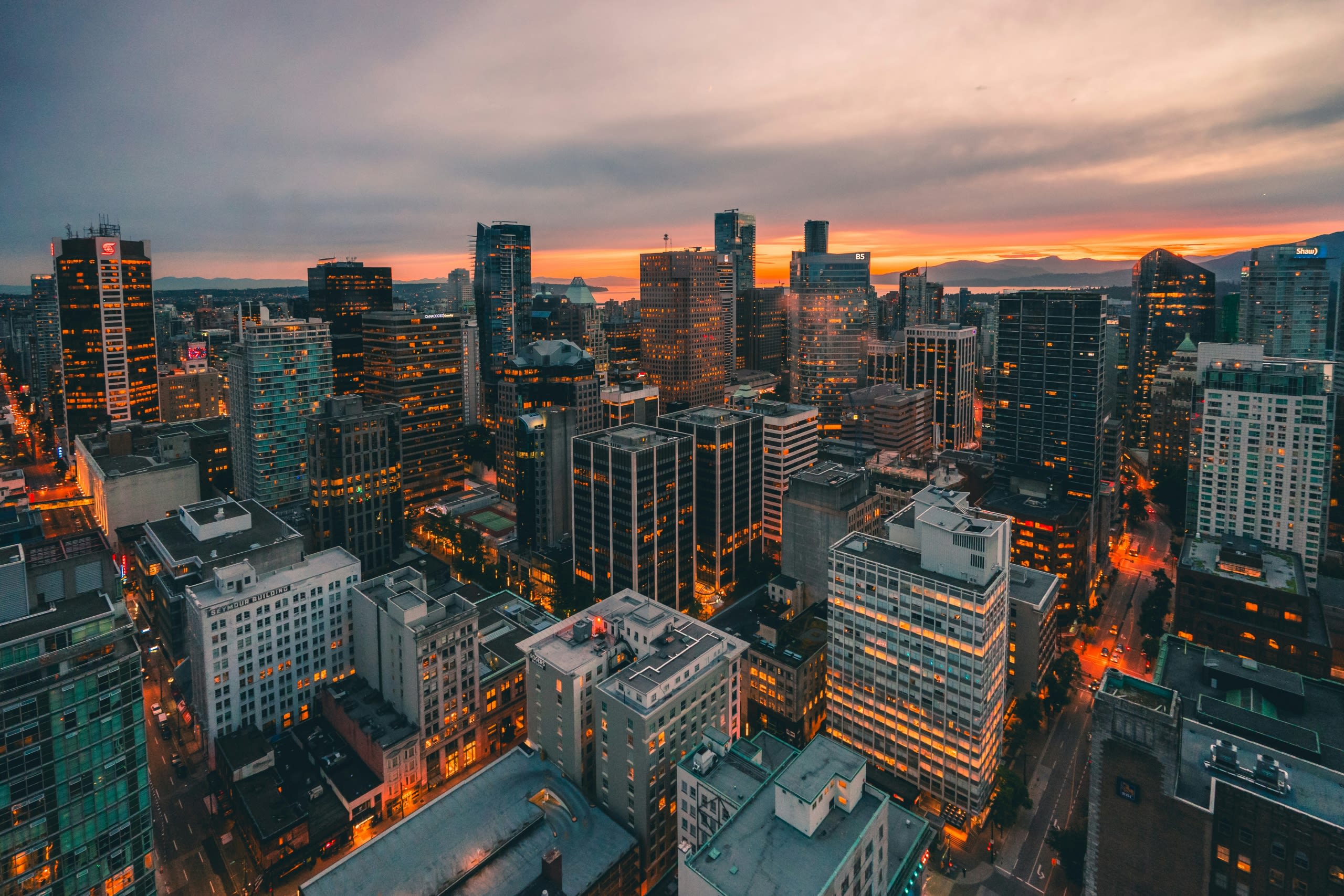 Cityscape at dusk with illuminated streets and sunset