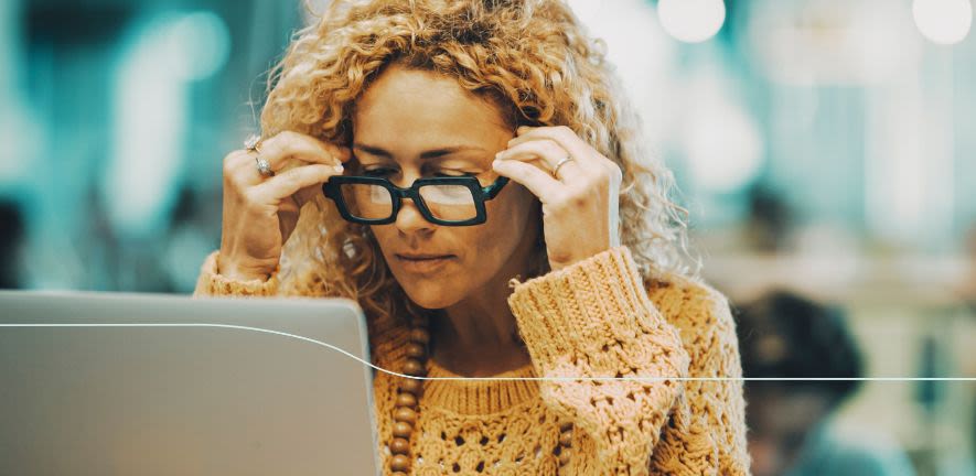 Woman in glasses looks at laptop